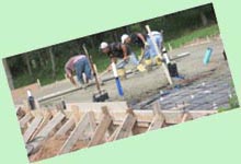 Workers smooth freshly poured concrete.